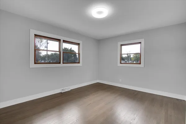 a view of a room with wooden floor and window