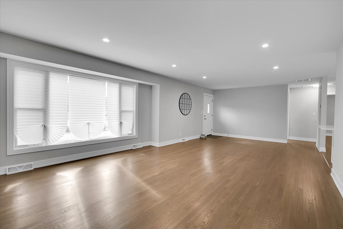 11550 Francis Road Mokena, IL 60448 - Photo 5 of 22 an empty room with wooden floor and windows with curtains view