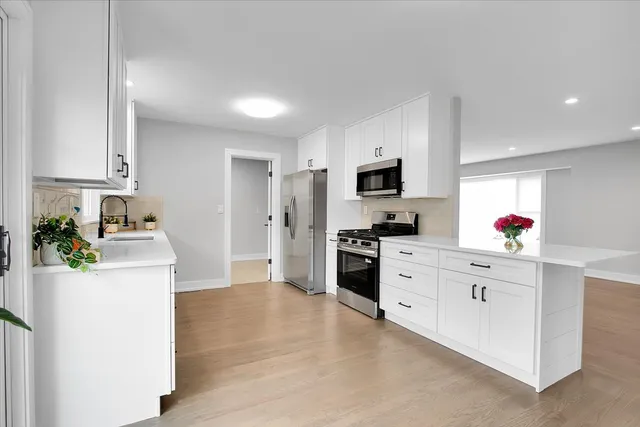 a kitchen with white cabinets and stainless steel appliances