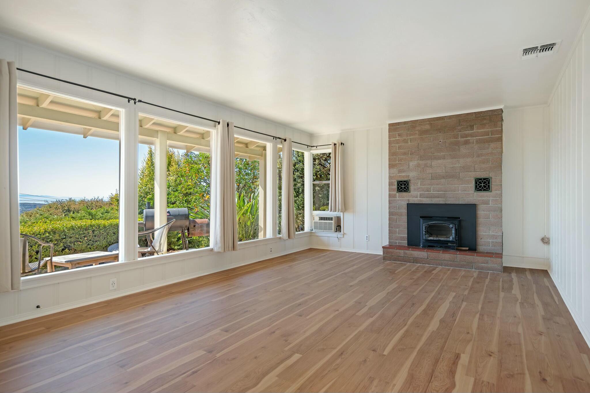 2986 Kenmore Place Santa Barbara, CA 93105 - Photo 6 of 49 a view of an empty room with wooden floor fireplace and a window