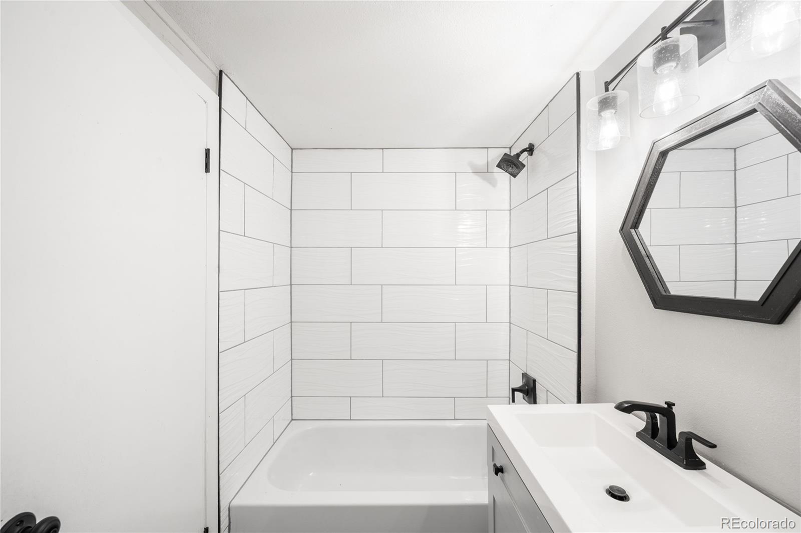 3855 Cook Street Denver, CO 80205 - Photo 15 of 22 a bathroom with a sink a toilet and a mirror