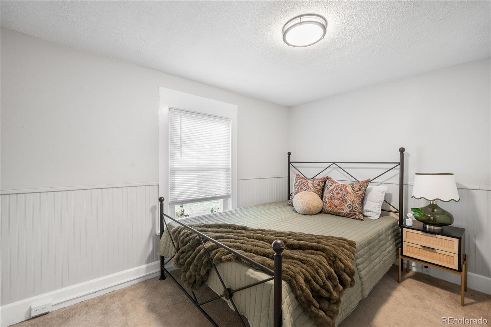 3855 Cook Street Denver, CO 80205 - Photo 17 of 22 a bedroom with a bed and a window