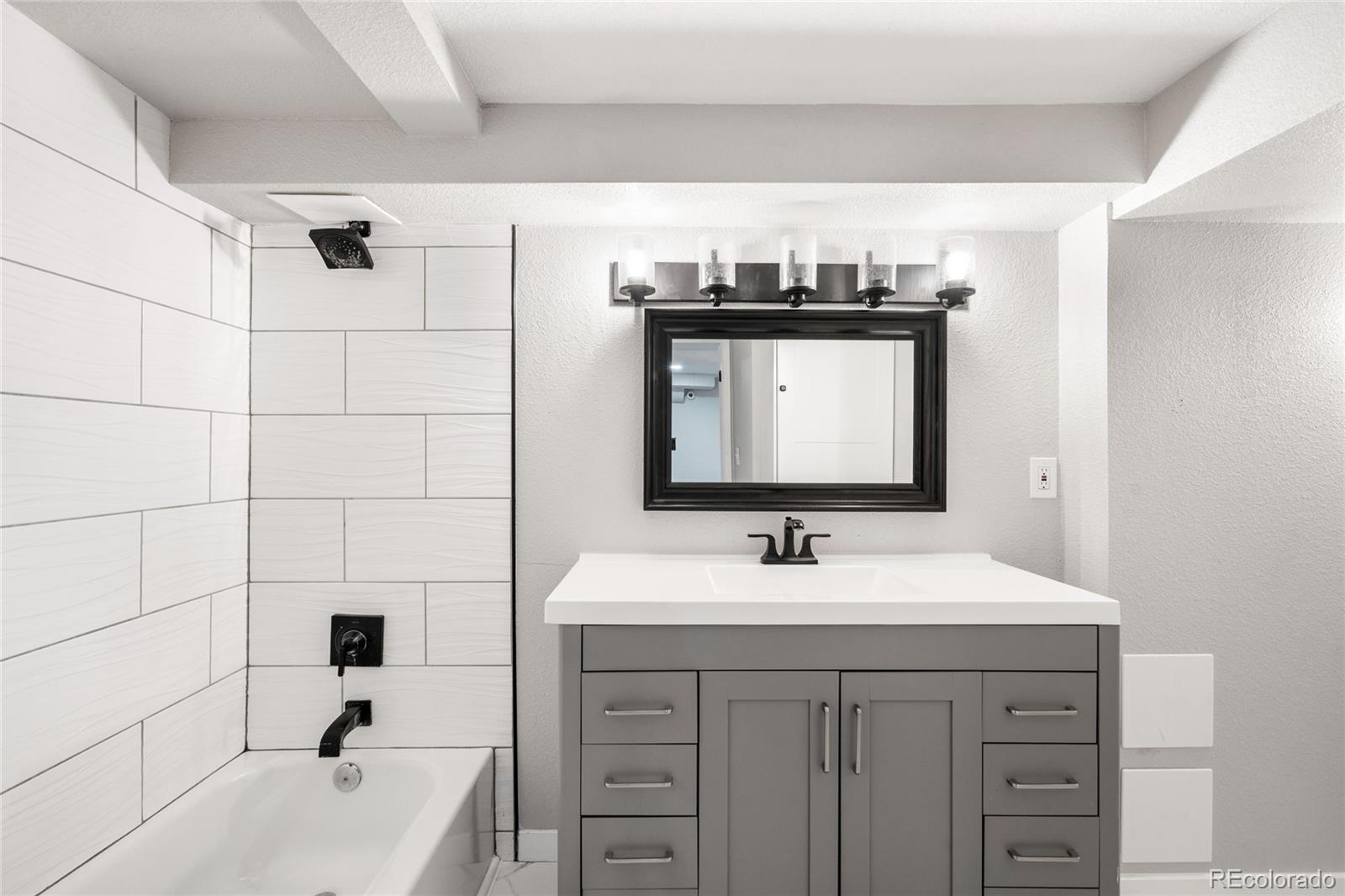 3855 Cook Street Denver, CO 80205 - Photo 20 of 22 a bathroom with a sink a vanity and a mirror