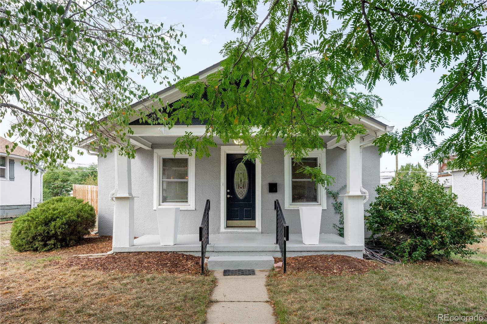 3855 Cook Street Denver, CO 80205 - Photo 2 of 22 front view of a house with a tree