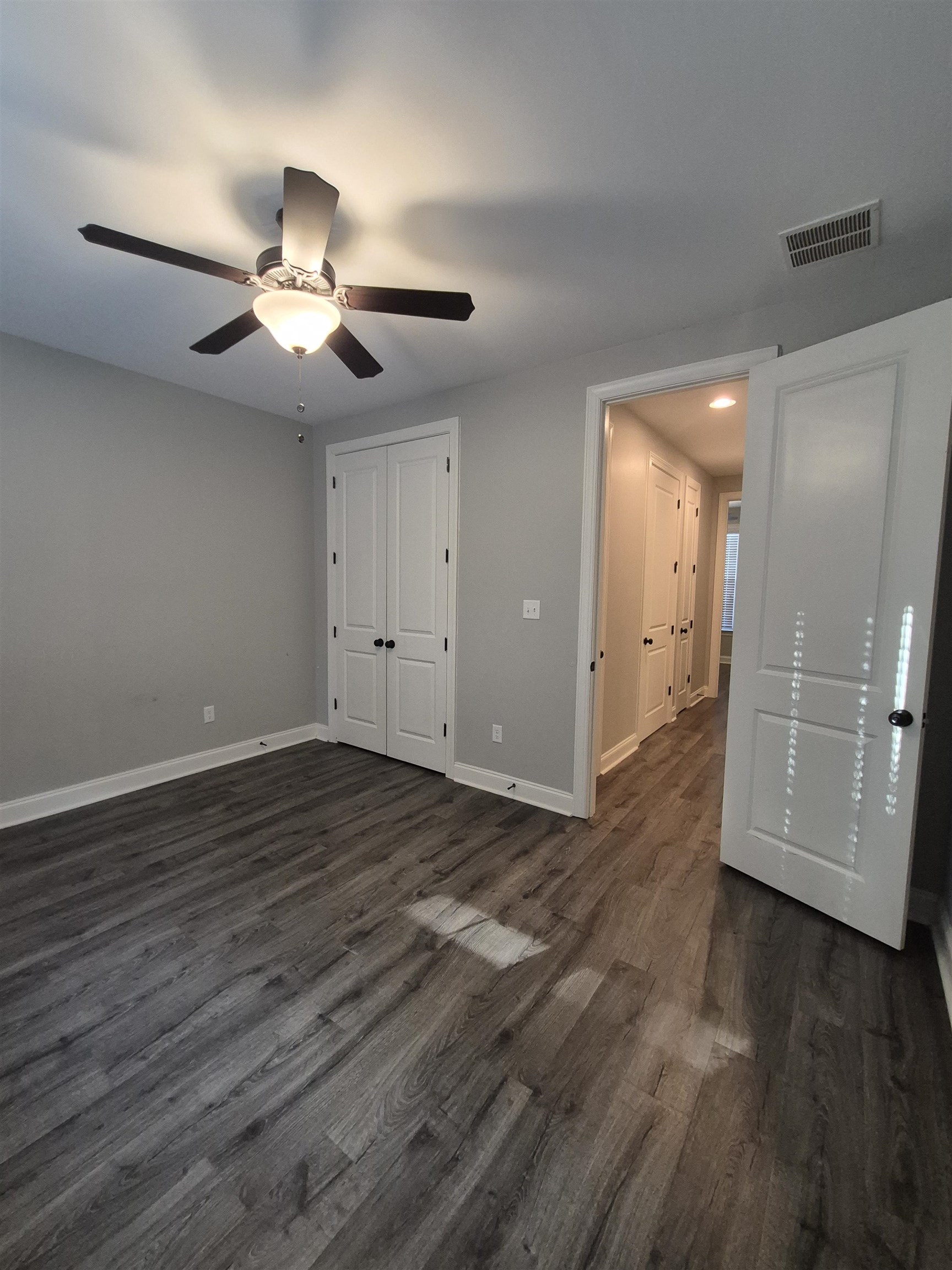 5120 Moudry Lane Lakeland, TN 38002 - Photo 10 of 34 Unfurnished bedroom with dark wood-type flooring, ceiling fan, and a closet