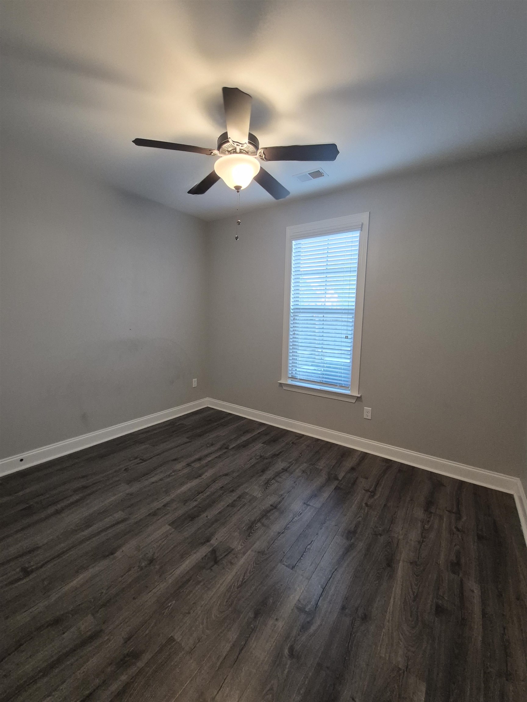 5120 Moudry Lane Lakeland, TN 38002 - Photo 13 of 34 an empty room with wooden floor chandelier fan and windows