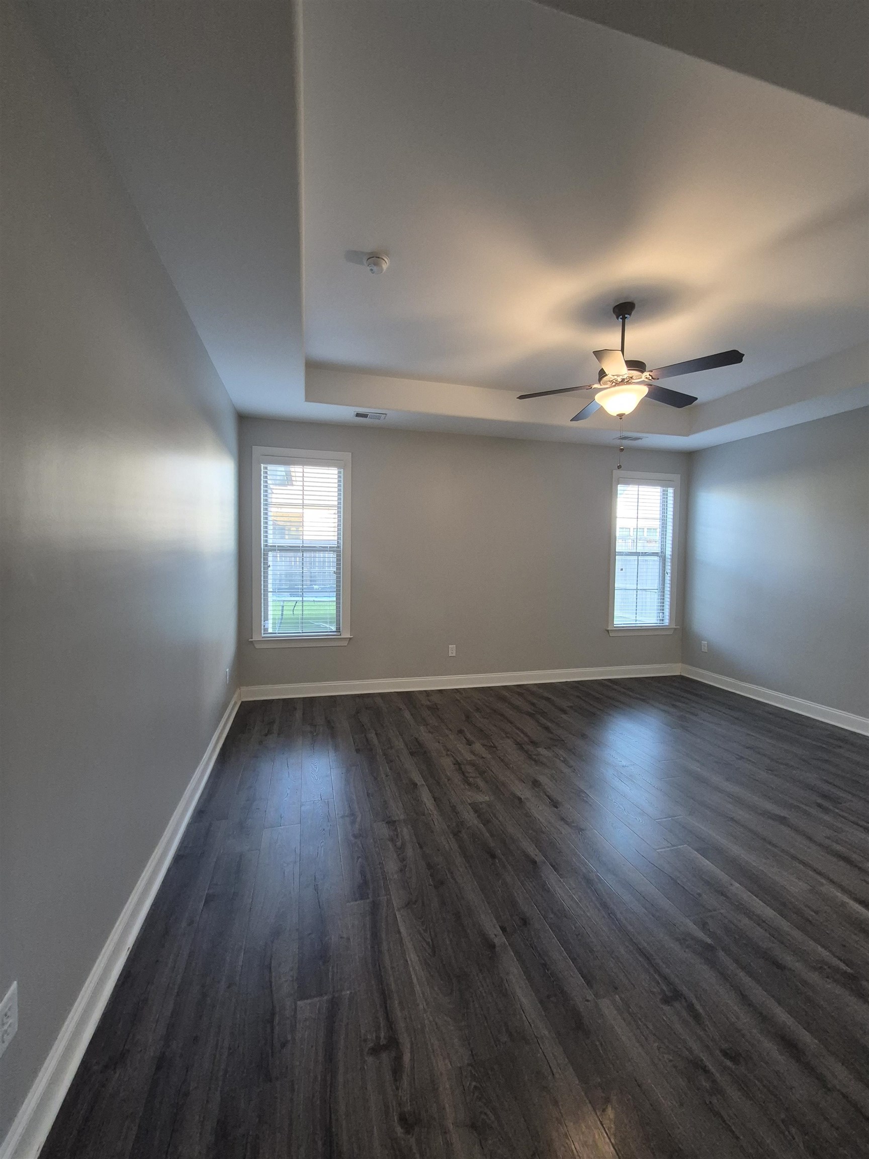5120 Moudry Lane Lakeland, TN 38002 - Photo 17 of 34 Bedroom featuring dark wood-type flooring, a tray ceiling, a ceiling fan, and a smoke detector