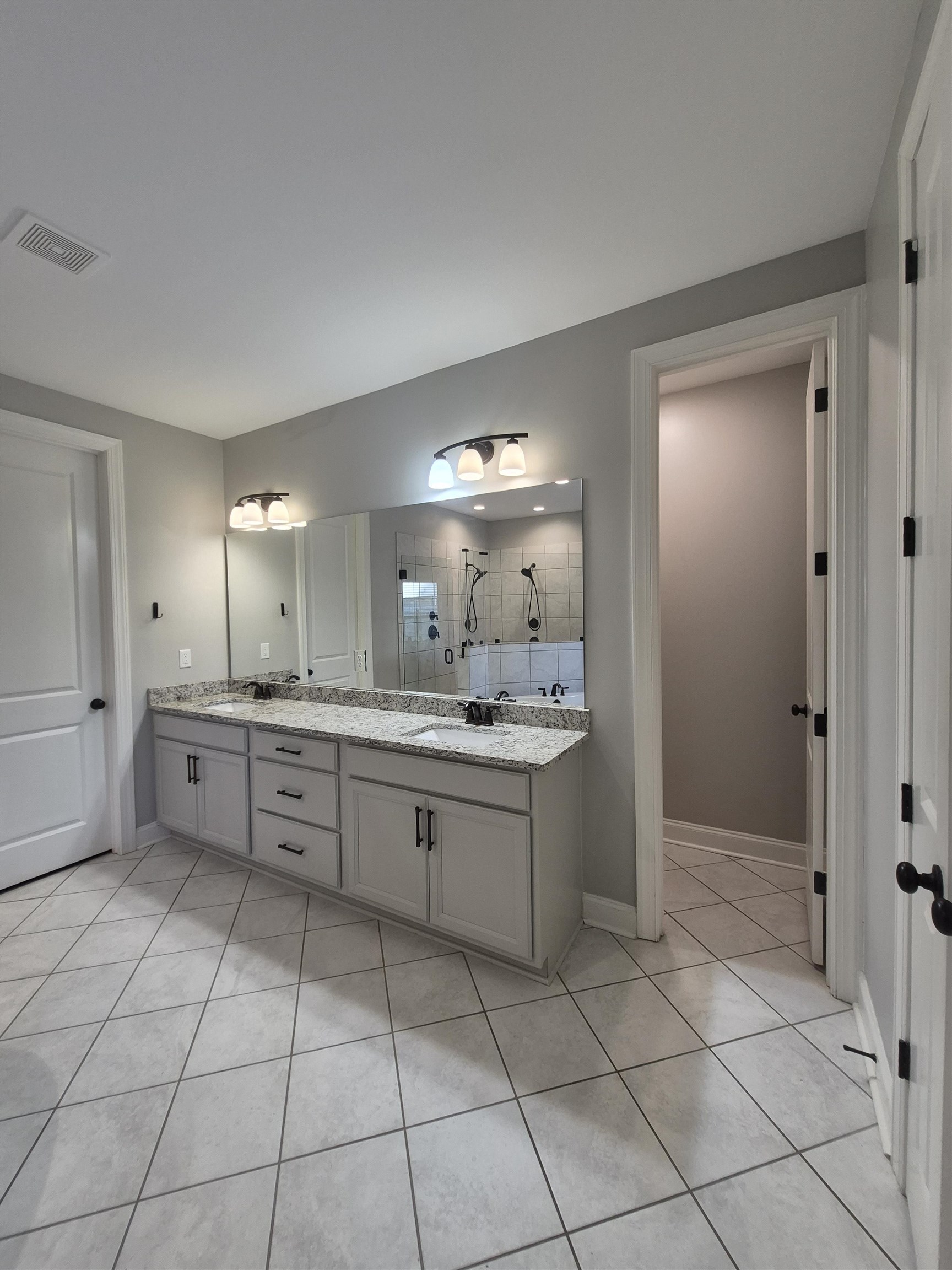 5120 Moudry Lane Lakeland, TN 38002 - Photo 22 of 34 Bathroom with tile patterned floors, double vanity, and tiled shower