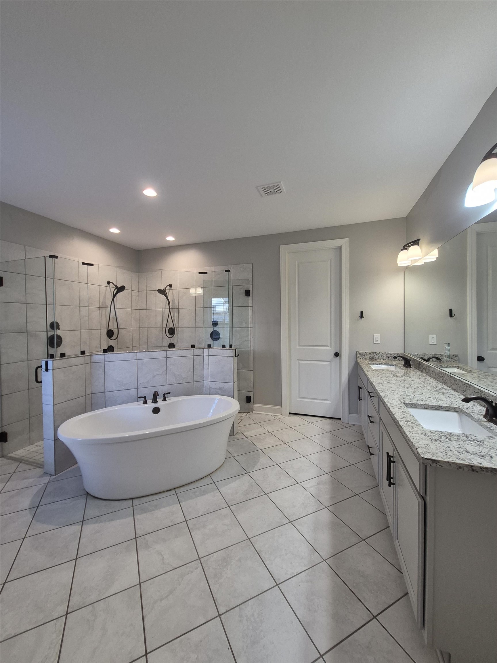 5120 Moudry Lane Lakeland, TN 38002 - Photo 23 of 34 a spacious bathroom with a granite countertop sink a toilet a mirror and bathtub