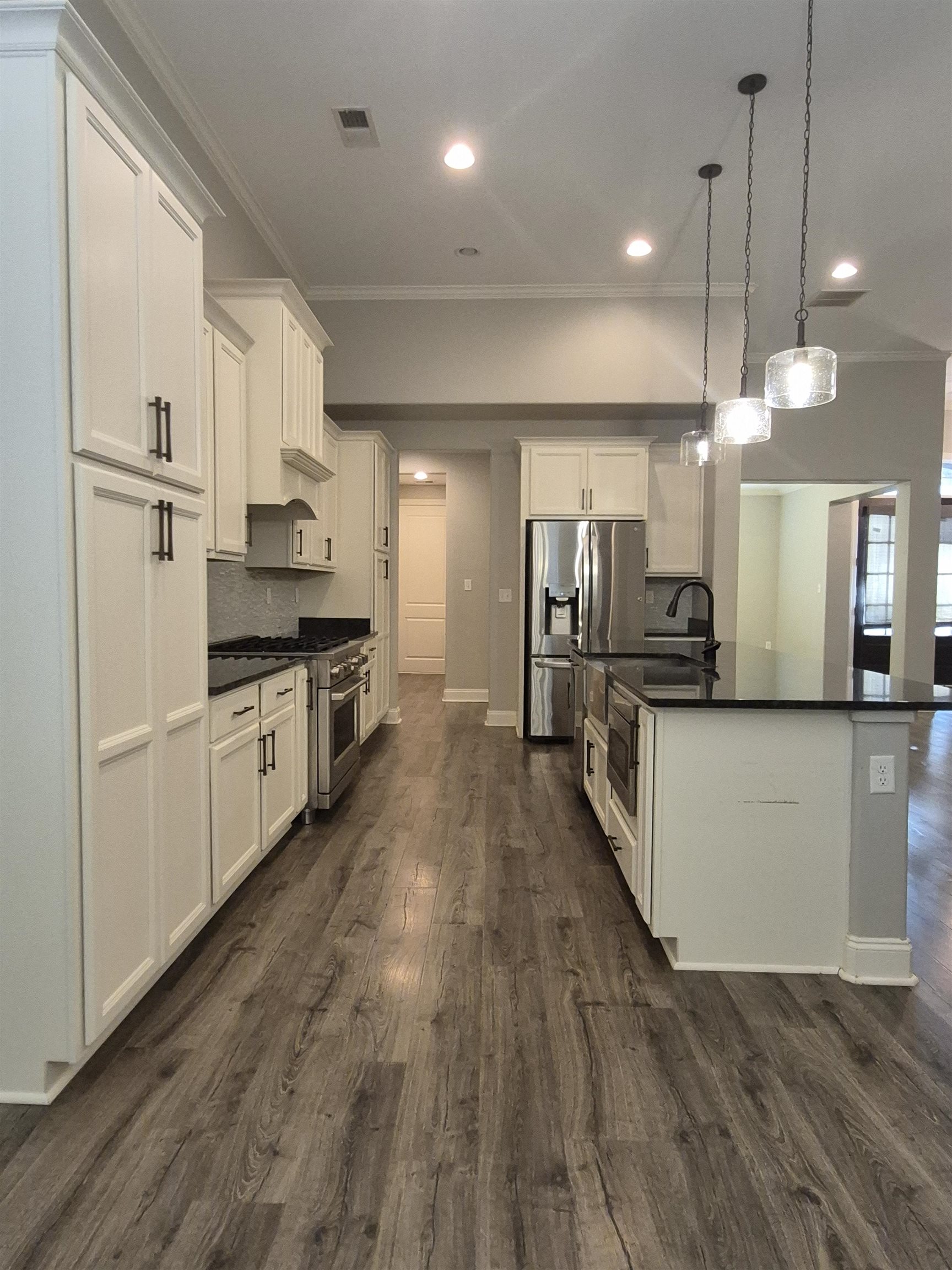 5120 Moudry Lane Lakeland, TN 38002 - Photo 9 of 34 a large kitchen with cabinets wooden floor and stainless steel appliances