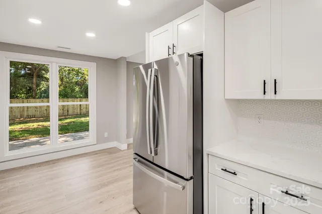 a view of a kitchen with a refrigerator cabinets and wooden floor