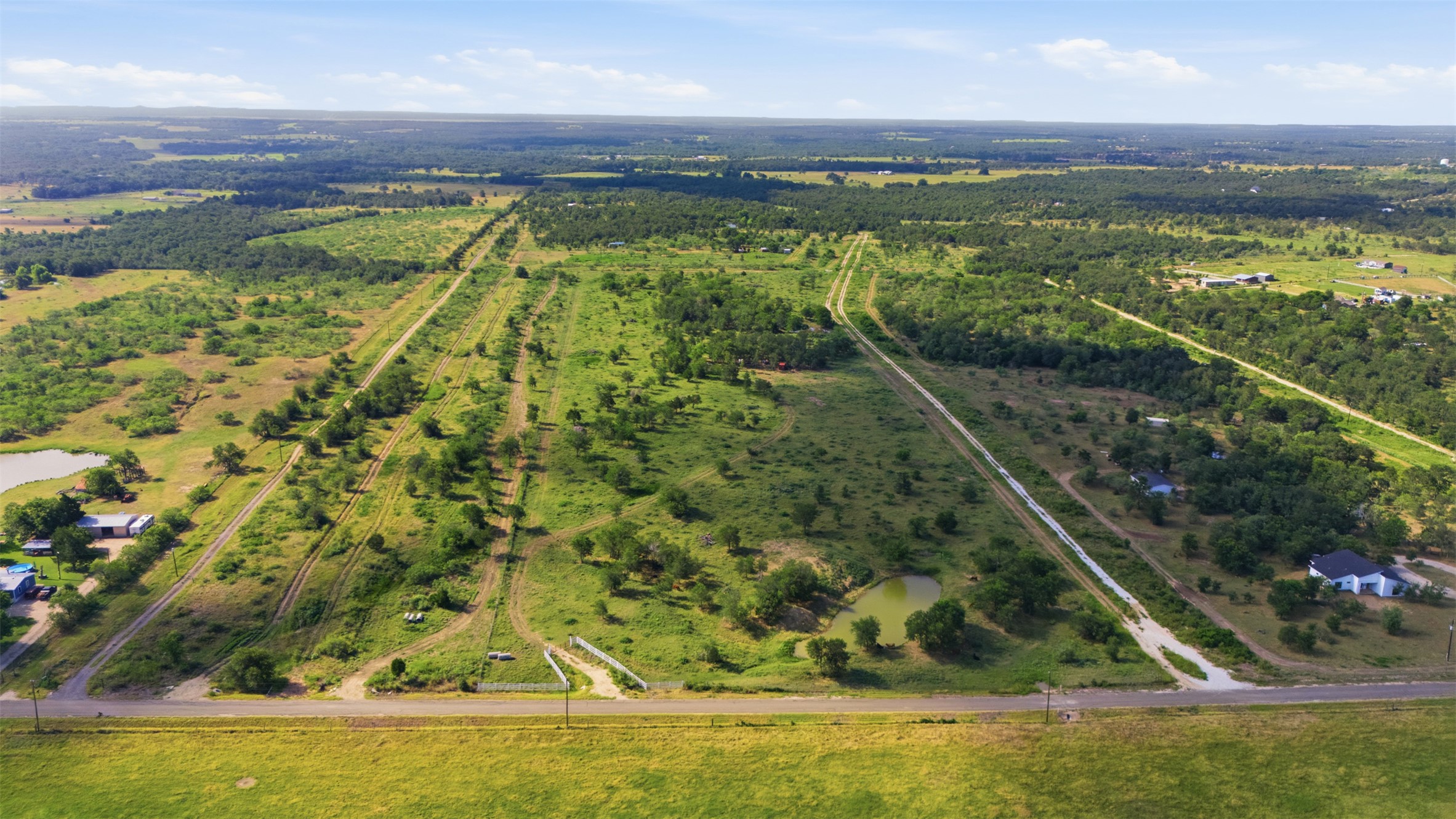 3280 County Road 466 Elgin, TX 78621 - Photo 5 of 13 Vast, open acreage offering a private pond and natural tree lines.