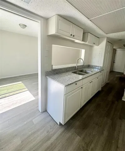a kitchen with granite countertop a sink and a stove