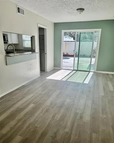 a view of a kitchen with wooden floor and a sink