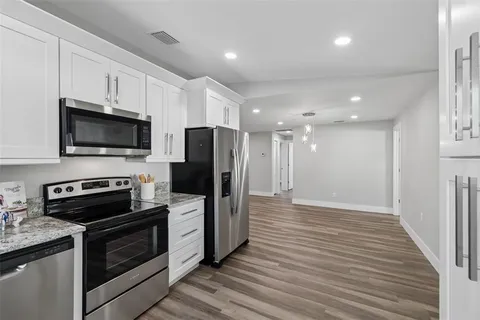 a kitchen with stainless steel appliances granite countertop a stove a sink and a microwave