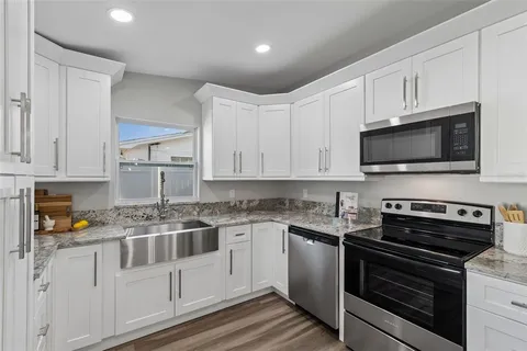 a kitchen with a refrigerator a sink and a stove top oven