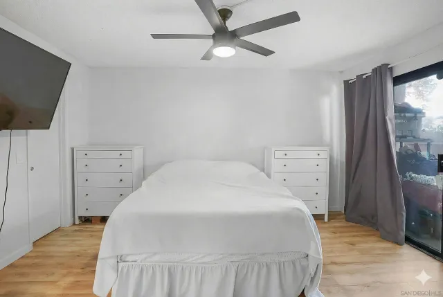 a bedroom with a bed and a flat tv screen on dresser