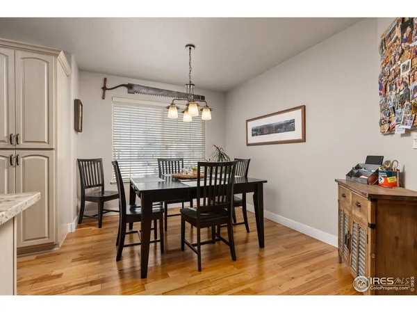 a kitchen with a sink dishwasher a dining table and chairs with wooden floor