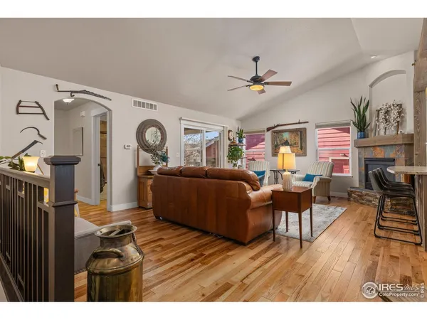 a living room with furniture a fireplace and wooden floor