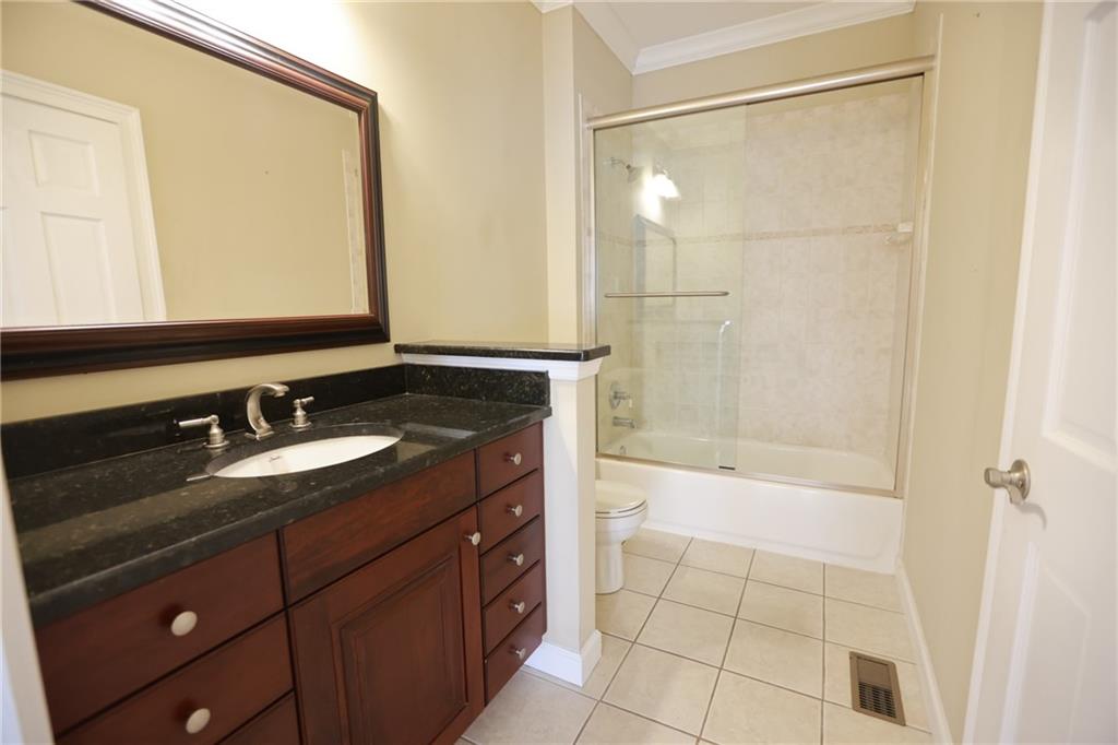 3541 Roswell Road Northeast, Unit 20 Atlanta, GA 30305 - Photo 14 of 72 a bathroom with a granite countertop sink mirror and shower