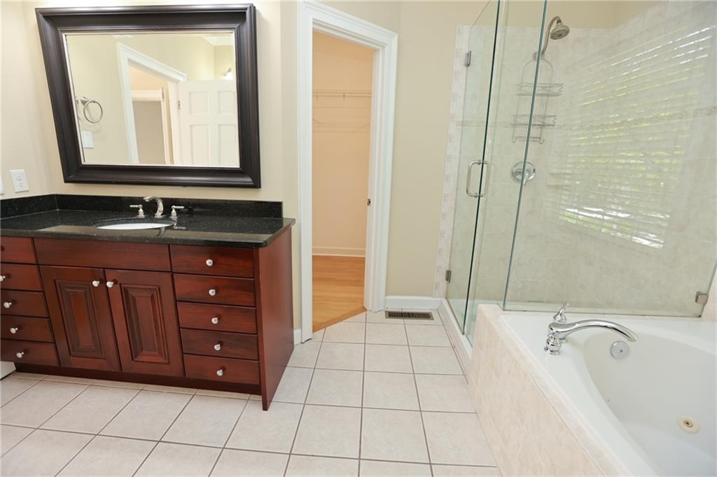 3541 Roswell Road Northeast, Unit 20 Atlanta, GA 30305 - Photo 22 of 72 a bathroom with a tub a sink and mirror