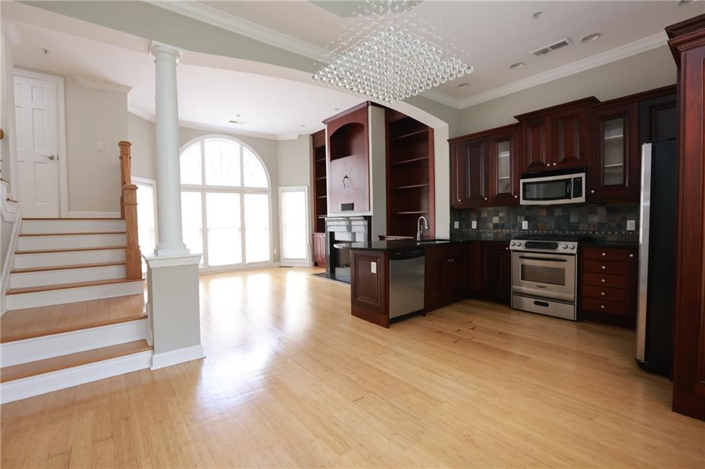 3541 Roswell Road Northeast, Unit 20 Atlanta, GA 30305 - Photo 38 of 72 a kitchen with stainless steel appliances granite countertop a stove top oven a sink dishwasher a refrigerator and a cabinets with wooden floor