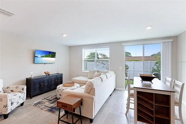a living room with furniture a flat screen tv and large window