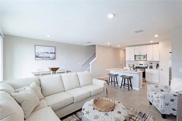a living room with furniture kitchen view and a table