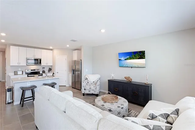 a living room with furniture and kitchen view