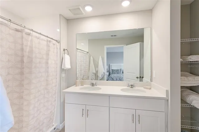 a bathroom with double sink and a mirror