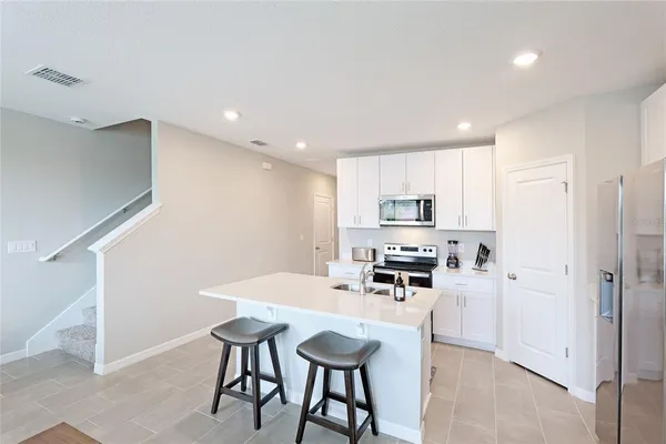 a kitchen with stainless steel appliances kitchen island granite countertop a refrigerator and a stove top oven