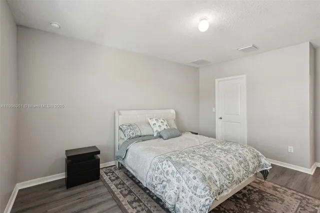 a bedroom with a bed and a painting on the wall