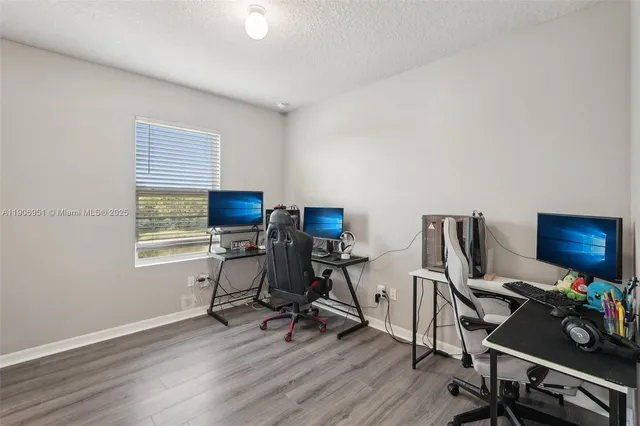 a view of a workspace with furniture and wooden floor