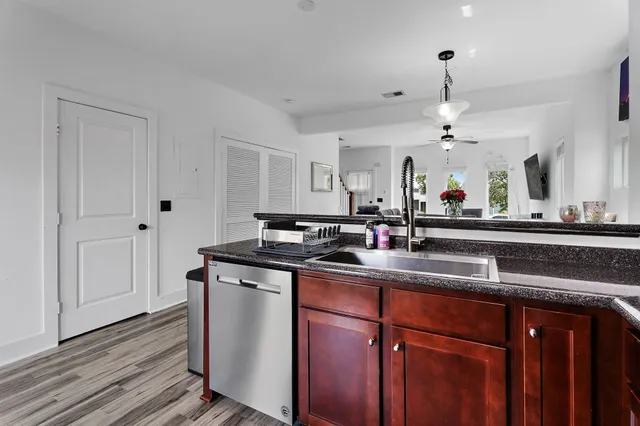 a kitchen with stainless steel appliances granite countertop a sink and wooden cabinets