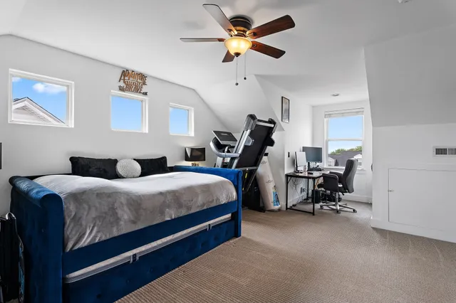 a bed room with a bed and a ceiling fan