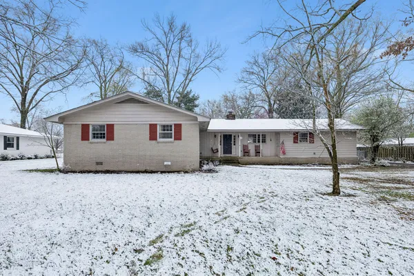 a white house that has a tree in front of it
