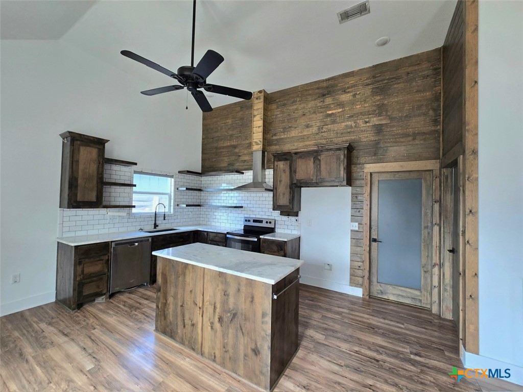 1005 Bridge Street Lampasas, TX 76550 - Photo 12 of 29 a kitchen with stainless steel appliances granite countertop wooden cabinets a stove top oven a sink and dishwasher