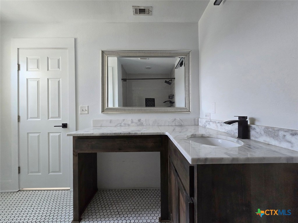 1005 Bridge Street Lampasas, TX 76550 - Photo 24 of 29 a bathroom with a sink and a mirror