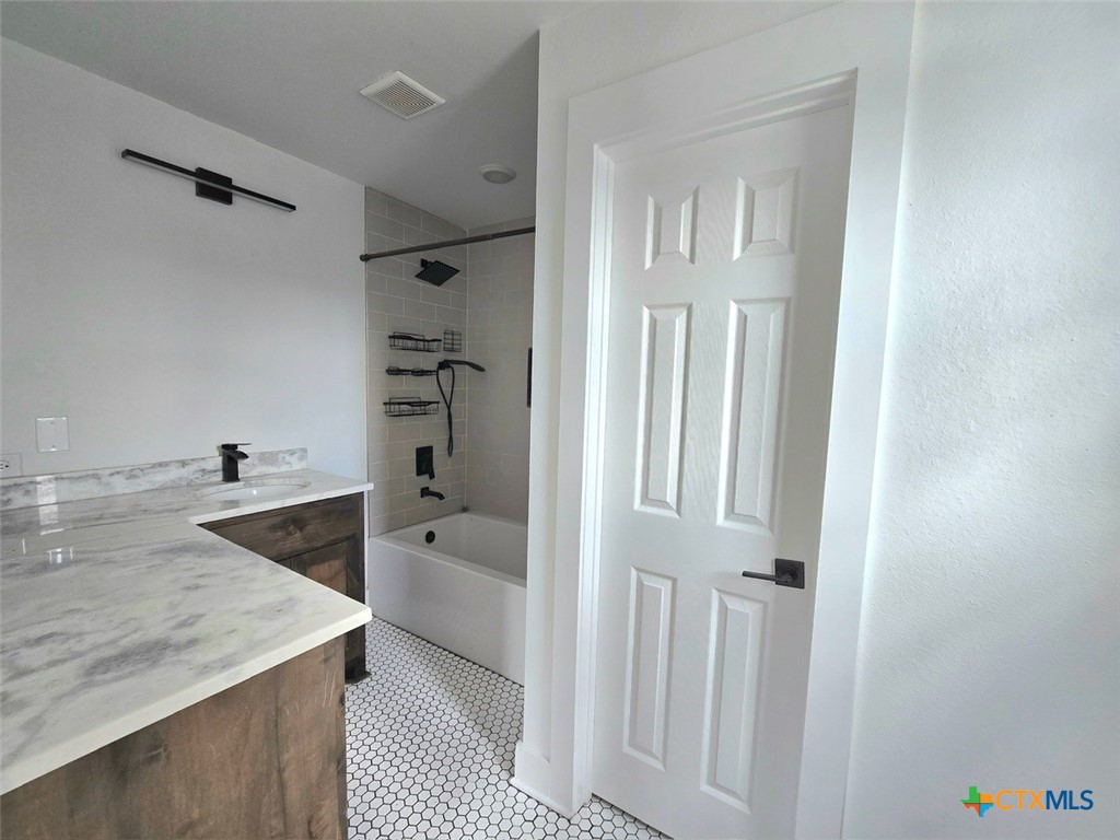 1005 Bridge Street Lampasas, TX 76550 - Photo 26 of 29 a kitchen with a refrigerator a sink and cabinets