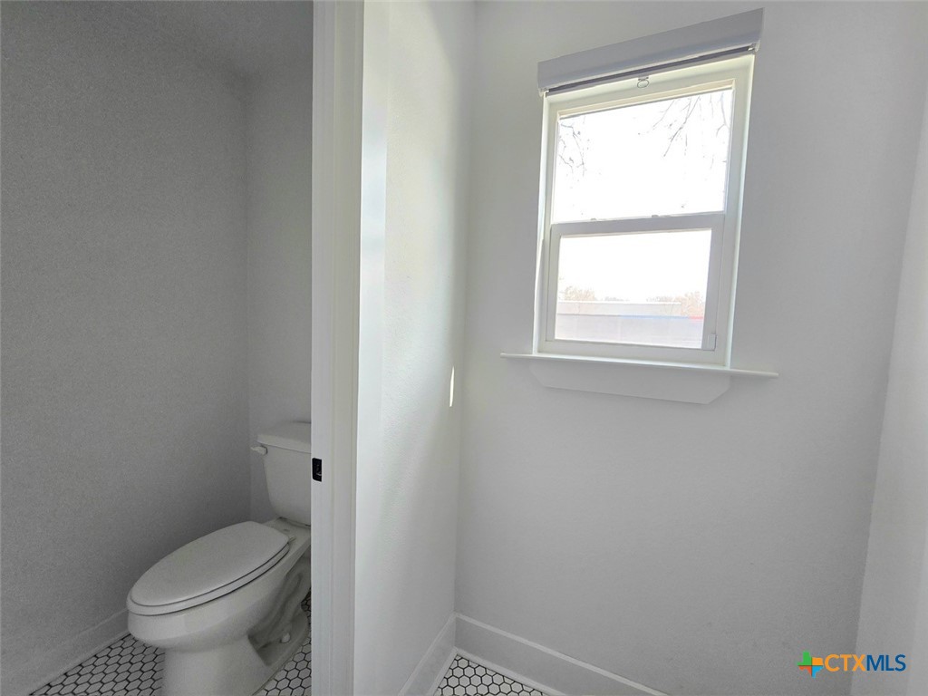 1005 Bridge Street Lampasas, TX 76550 - Photo 27 of 29 a white toilet sitting next to a window in a bathroom