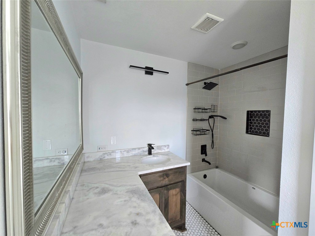 1005 Bridge Street Lampasas, TX 76550 - Photo 28 of 29 a bathroom with a tub a sink and a large mirror