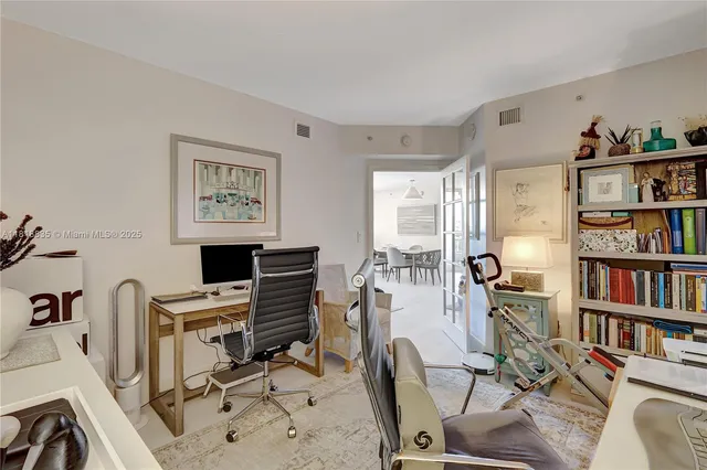 a view of a workspace with furniture and a book shelf