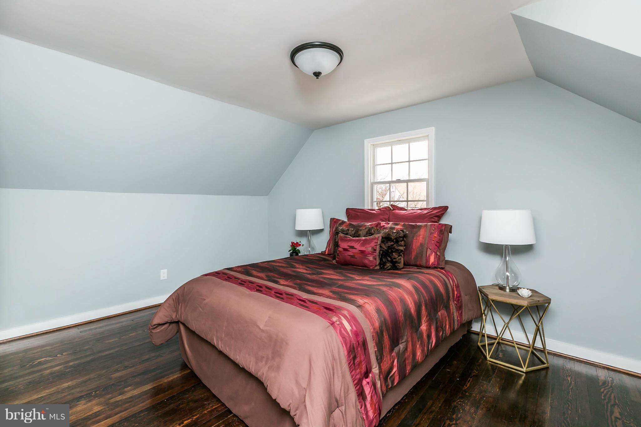 5504 Catalpha Road Baltimore, MD 21214 - Photo 14 of 28 a bed sitting in a bedroom next to a window and a chandelier