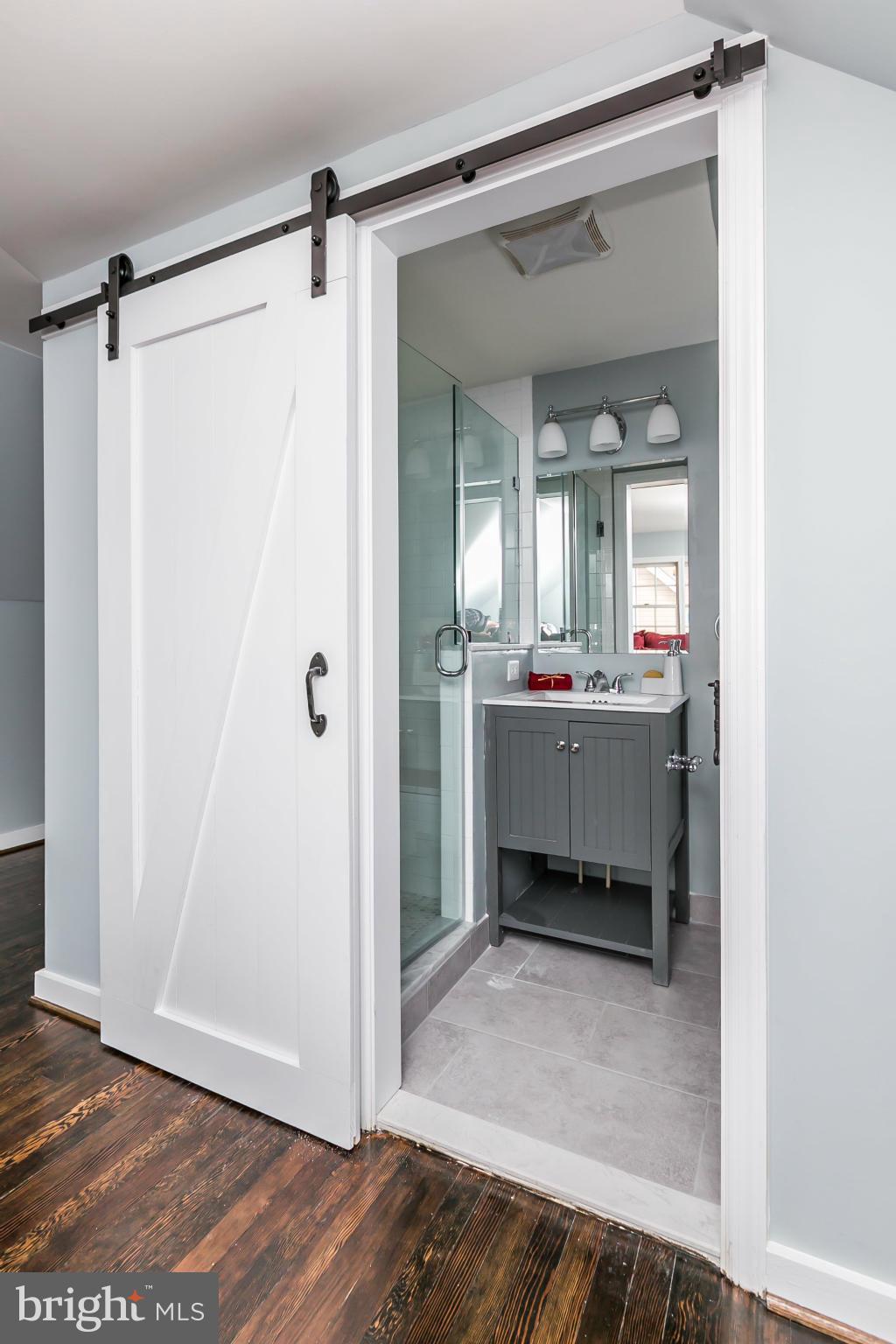 5504 Catalpha Road Baltimore, MD 21214 - Photo 17 of 28 a bathroom with a sink mirror and a shower