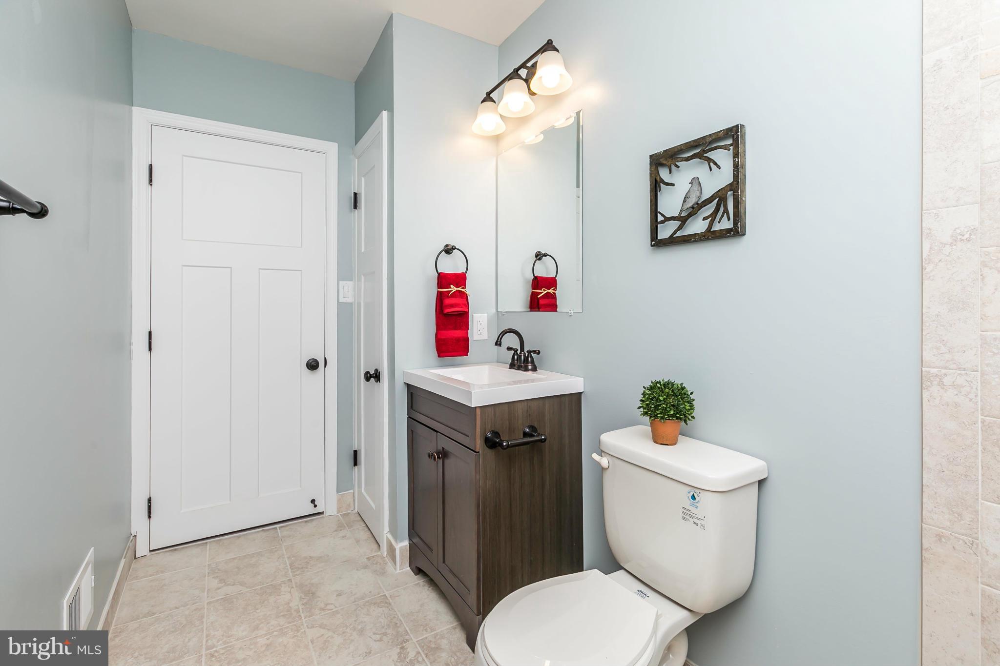 5504 Catalpha Road Baltimore, MD 21214 - Photo 22 of 28 a bathroom with a sink vanity mirror and toilet