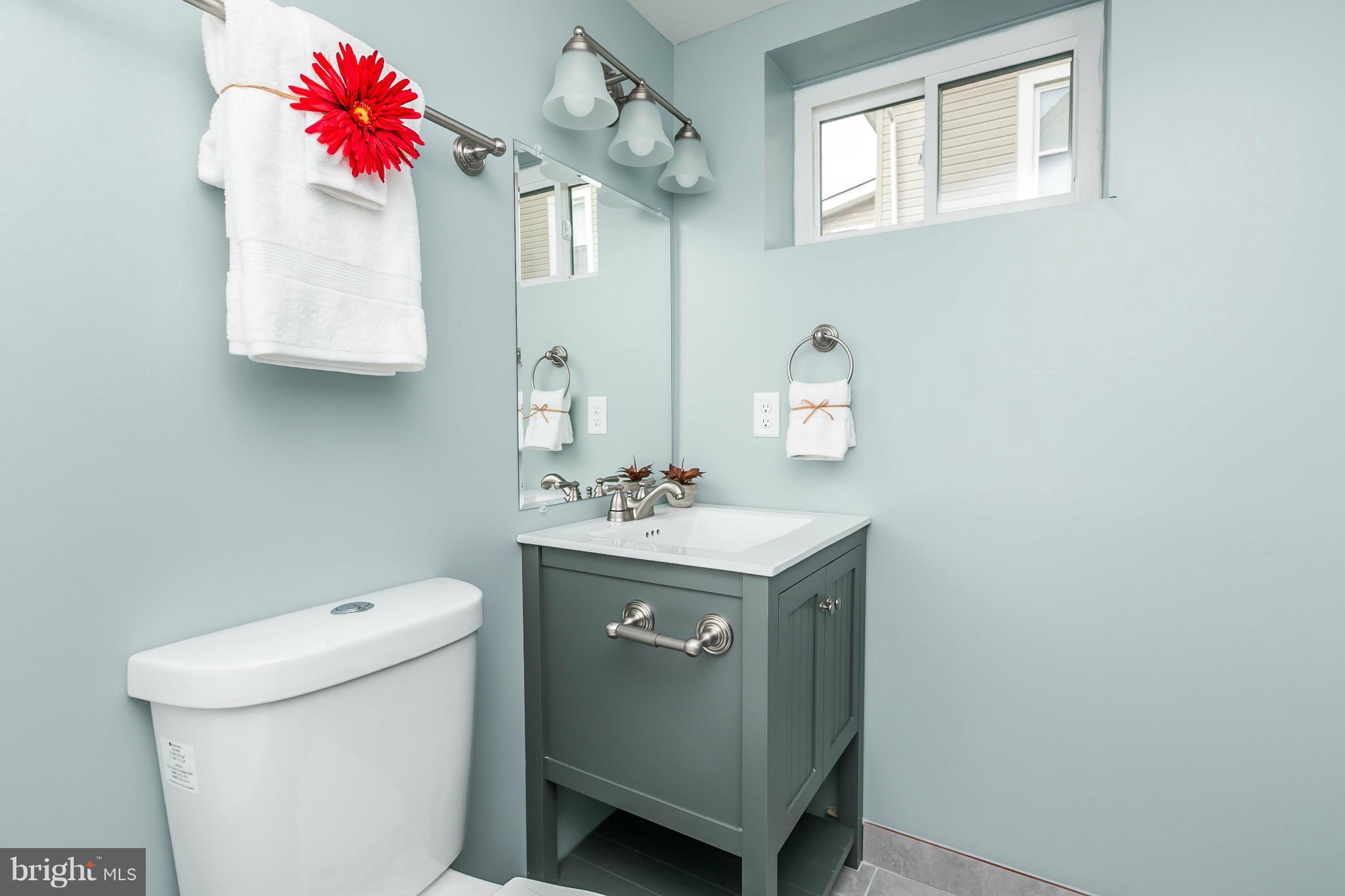 5504 Catalpha Road Baltimore, MD 21214 - Photo 26 of 28 a bathroom with a sink vanity mirror and toilet