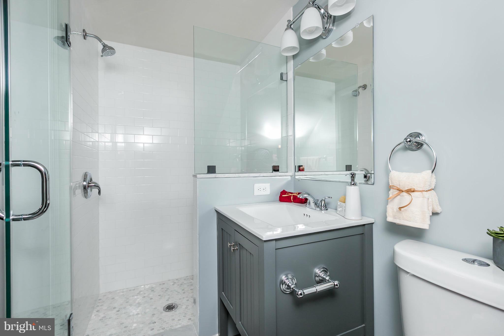 5504 Catalpha Road Baltimore, MD 21214 - Photo 27 of 28 a bathroom with a sink vanity mirror and toilet
