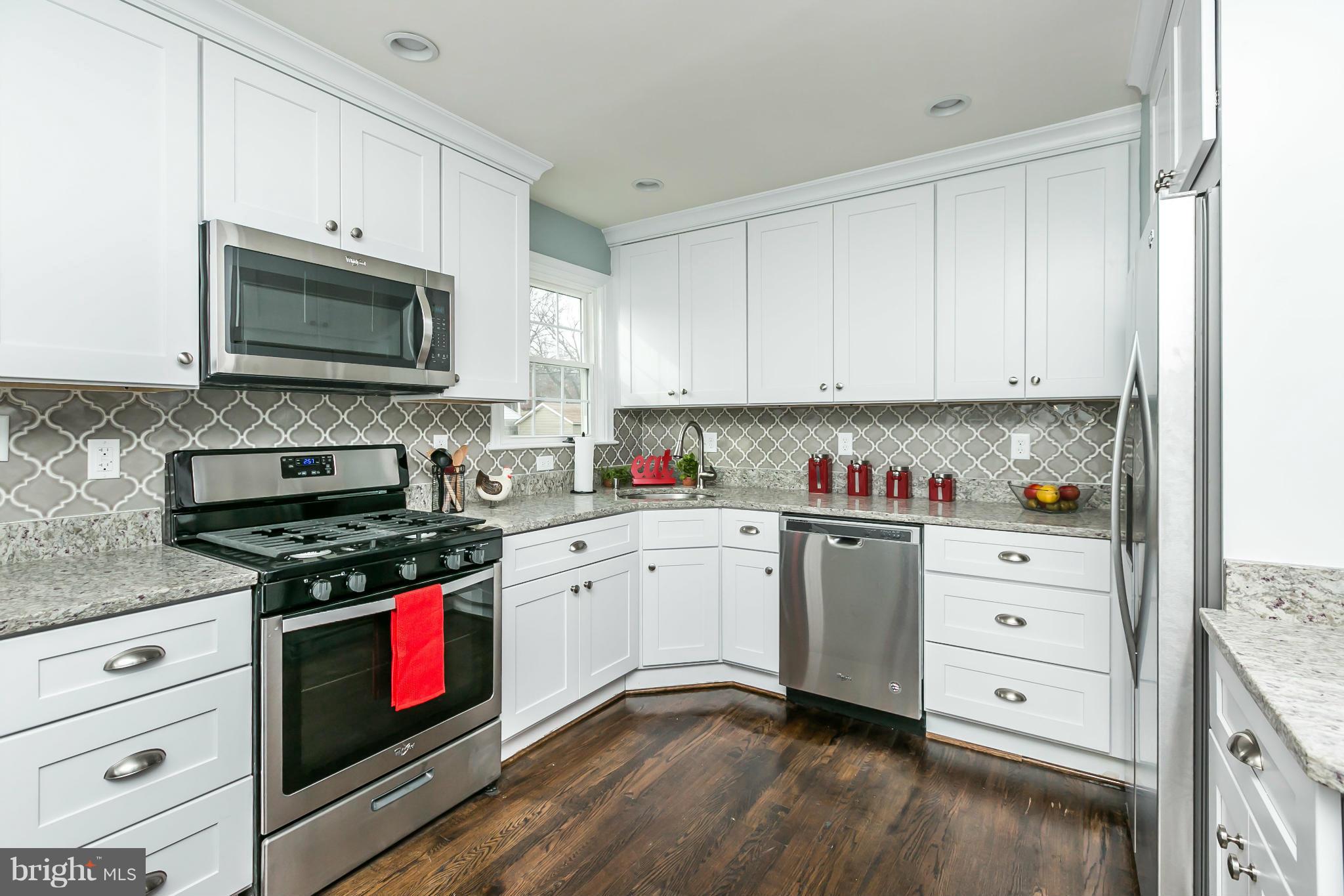 5504 Catalpha Road Baltimore, MD 21214 - Photo 7 of 28 a kitchen with stainless steel appliances granite countertop a stove a sink and a microwave