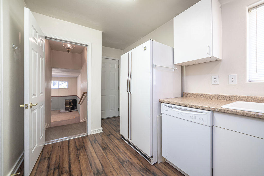 19132 Pumice Butte Road Bend, OR 97702 - Photo 23 of 49 a kitchen with a refrigerator a sink and dishwasher with wooden floor