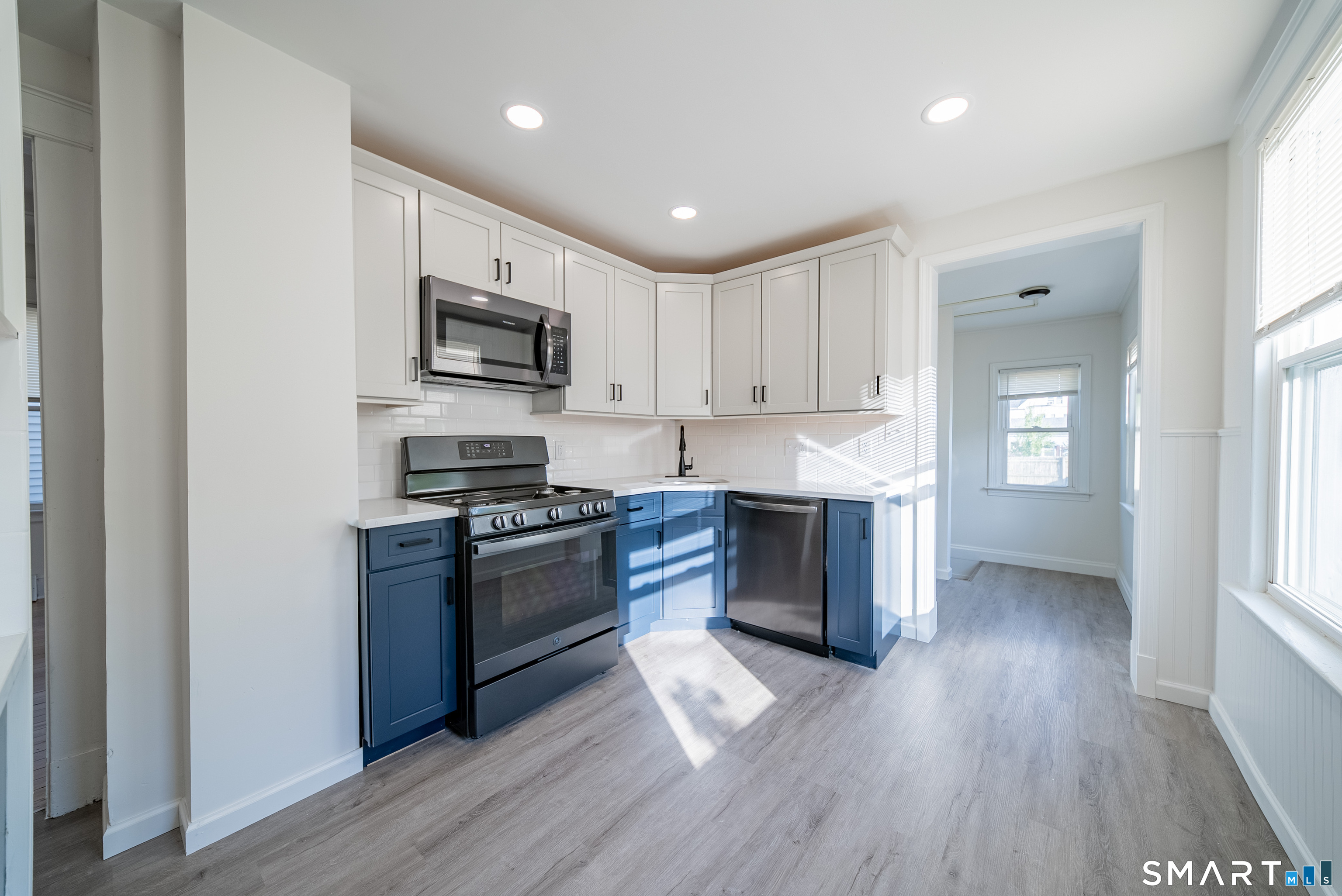 50 Jones Street West Haven, CT 06516 - Photo 2 of 21 a kitchen with stainless steel appliances granite countertop a stove top oven a sink dishwasher a refrigerator and a microwave oven with wooden floor
